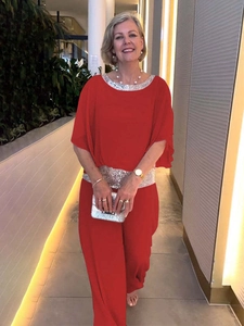 Detail of red cape top with silver sequins on neckline and waist with wide-leg pants