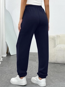 Rear view of dark blue high-waisted joggers with elastic cuffs and drawstring waist