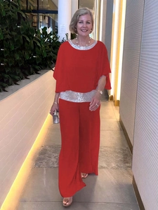 Detail of red chiffon evening set featuring sequined round neck and wide-leg trousers