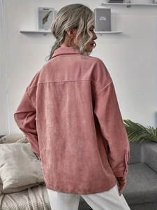 Detail shot of dusty rose corduroy shirt showing thick ribbed texture and loose drop shoulder