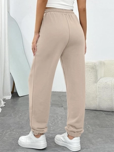 Rear view of high-waist beige joggers with drawstring and ribbed cuffs details