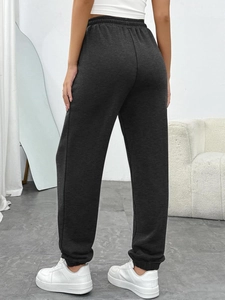 Detail view of charcoal gray high-waisted joggers with elastic cuffs and back fit design