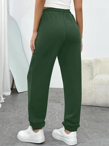 Back view of high-waisted dark green joggers with elastic cuffs and soft knit fabric