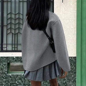 Back view of a grey double-breasted wool coat with unique curved hem and pleated skirt