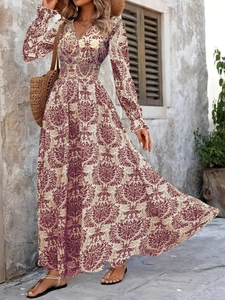 Bohemian V-neck maxi dress with vintage print and long sleeves in a rustic outdoor setting