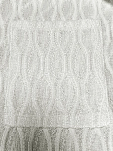 Detail van witte gebreide stof met unieke 3D-golfvormige ovale jacquardtextuur
