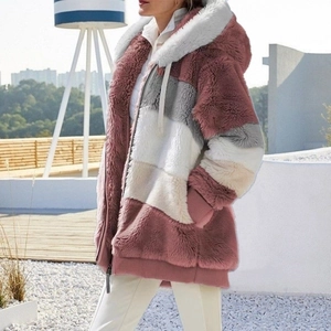 Detail of color-block faux fur hooded jacket with zipper closure and warm plush texture
