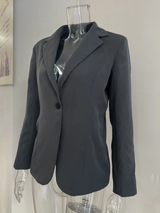 Détail d'un blazer femme gris foncé avec revers classique et fermeture à un seul bouton