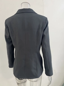 Vue arrière d'un blazer noir ajusté pour femme avec taille cintrée et tissu de qualité lisse
