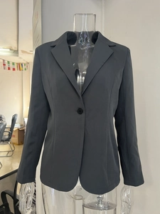 Détail d'un blazer gris pour femme avec fermeture à bouton unique et revers classique