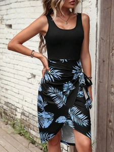Detail of summer sleeveless dress featuring black bodice and tropical leaf print skirt