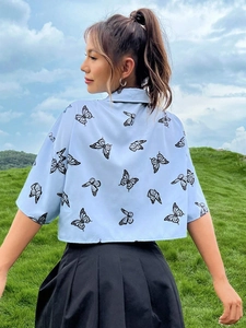 Vista trasera de camisa azul claro de manga corta con estampado detallado de mariposas negras