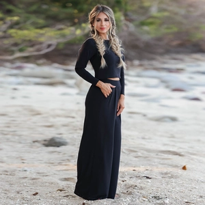 Outdoor shot of a black two-piece set with a long sleeve crop top and wide-leg pants