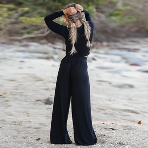 Rear view of black long sleeve top and high waist wide leg pants set on beach