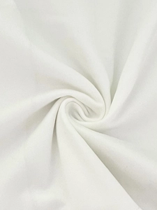 Close-up of white layered cotton fabric showing soft texture and ruffle details on dress