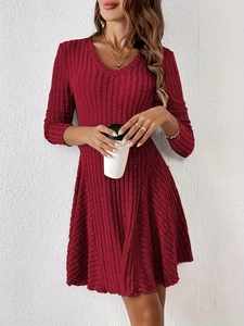 Detailed V-neckline of a deep red knit A-line dress with vertical ribbed texture