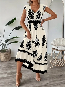 Détail du col en V et de l'imprimé bohème sur une robe midi d'été blanche cintrée