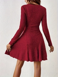 Detailed close-up of dark red ribbed knit fabric and long sleeve cuff of A-line dress