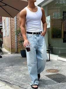 Men's white slim fit tank top paired with wide-leg light blue jeans for summer style
