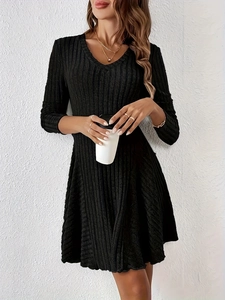 Detail of V-neckline and ribbed knit texture on a long-sleeve black A-line dress
