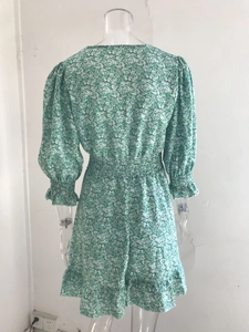 Detail view of the elastic waist and floral print pattern on the green bohemian dress