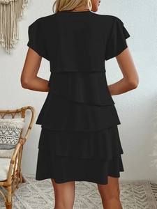 Back view detail of a layered black chiffon mini dress with tiered ruffle hem and cap sleeves
