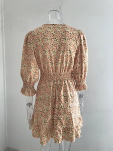 Detail of bohemian floral summer dress with elastic waist and ruffled sleeve cuffs