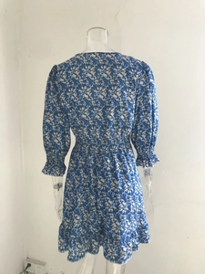 Detail view of waist elastic smocking and floral print on a blue bohemian midi dress