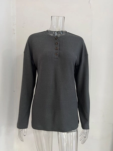 Detailed view of dark grey knit fabric with vertical ribbing and buttoned Henley neckline