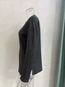 Detailed side view of dark grey ribbed knit sweater featuring a stylish side split hem