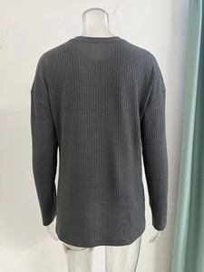Detail view of the back of a dark grey ribbed knit sweater with dropped shoulders