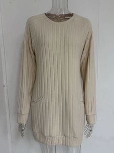 Detailed close-up of beige ribbed knit texture and two front patch pockets on the long sleeve top