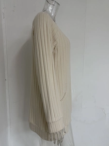 Close-up of ribbed knit texture and side pocket on a long-sleeved beige knit tunic