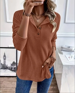 Detail of caramel knit Henley top with textured ribbing and three-button neckline