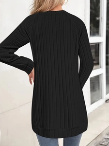Back view of black ribbed knit long sleeve tunic top showing texture and slim fit design