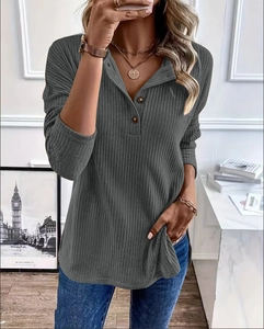 Detail of dark grey ribbed knit hoodie with three decorative buttons on the V-neckline