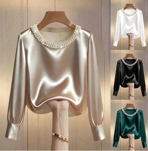 Detail view of elegant satin blouse with pearl-embellished neckline in four rich colors