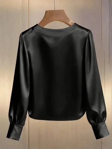 Detailed view of black satin fabric blouse featuring elegant lantern sleeves and round neck