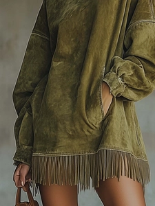 Detailed close-up of army green suede dress featuring fringe hem and side pocket texture