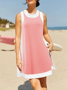 Detail of a pink and white sleeveless sundress with a layered two-piece look at the beach