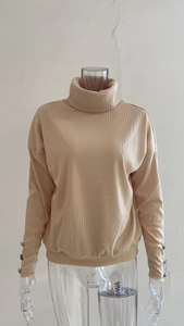 Detailed macro shot of ribbed knit texture and button decorative cuffs on a beige sweater