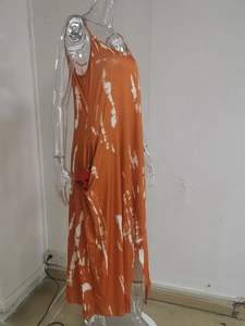 Detail of side pocket on orange and white tie-dye dress with a phone showing depth