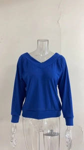 Detail of blue V-neck knitted sweater with ribbed texture and loose long sleeves