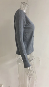 Detailweergave van grijs gebreid vest met V-hals, geribbelde manchetten en slanke pasvorm