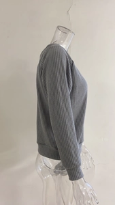 Detail of grey ribbed knit sweater featuring V-neckline and vertical texture