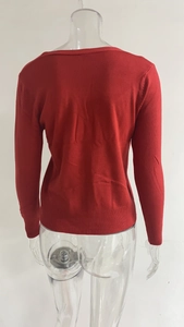 Achteraanzicht van rood gebreid vest met geribbelde manchetten en zachte woltextuur