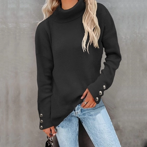 Detail of black ribbed knit sweater with silver buttons on the cuffs and high neck collar