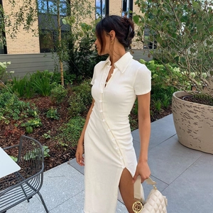 Detail of white waffle knit dress showing side buttons and elegant high slit design