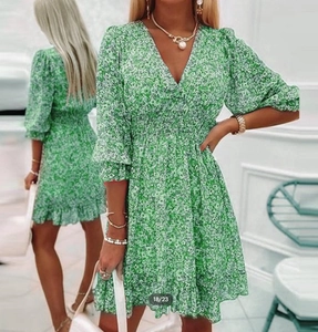 Detailed view of green floral dress featuring a V-neckline and smocked waist design