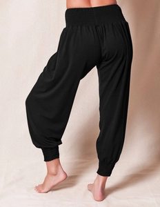 Detail of high-waist smocked waistband and elastic cuffs on black harem yoga pants